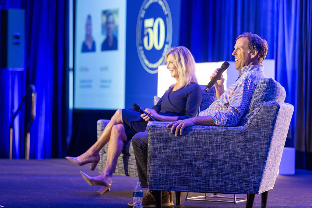 Two panelists seated on stage at the Bell Partners 50th anniversary corporate conference