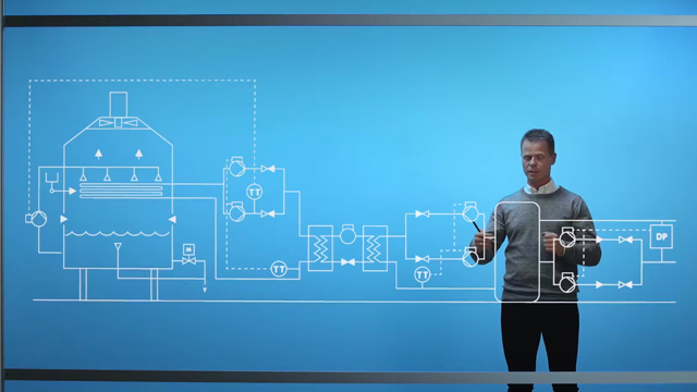 A man pointing to drawings in front of him for an Ecolab video.