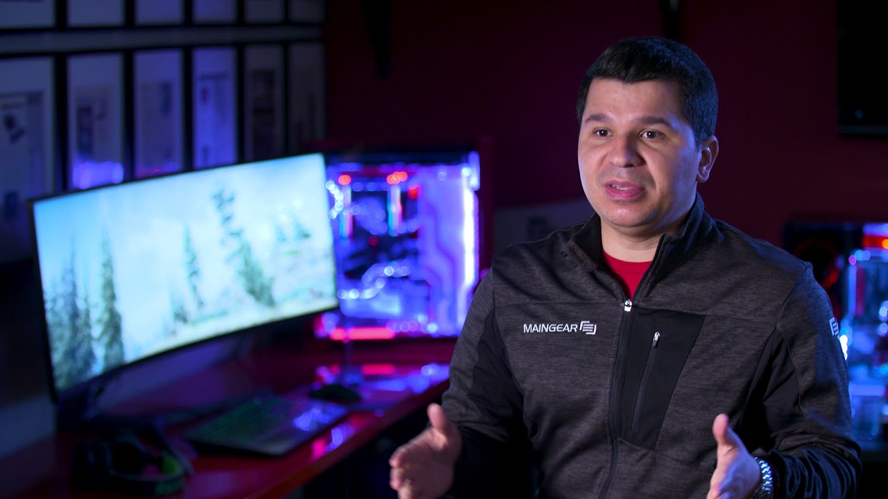 A man being interviewed with computers behind him.
