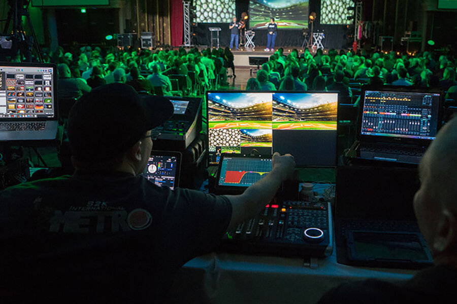 AV technician managing video and audio feeds at a live corporate event