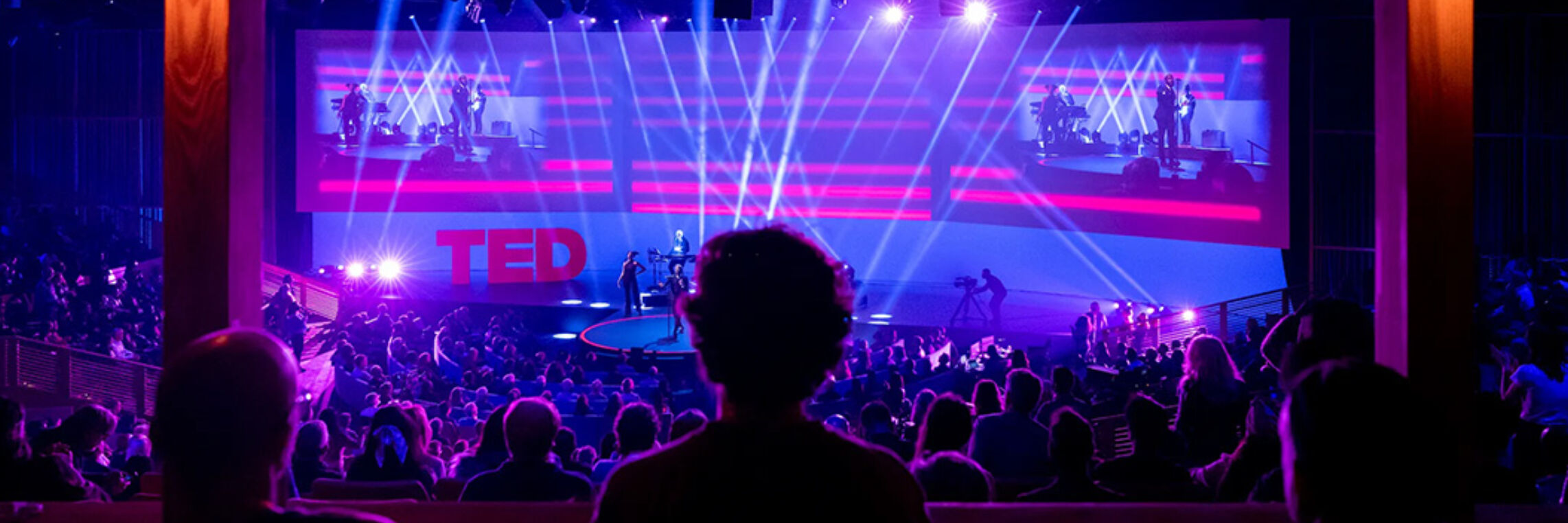 TED Talk corporate event production from audience perspective with stage lighting