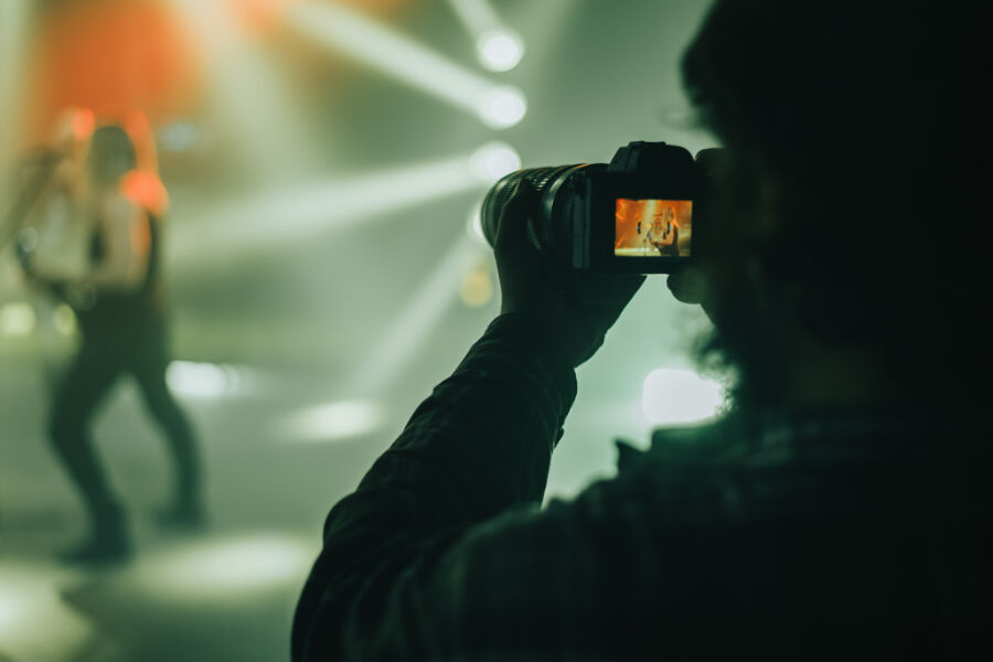 Photographer capturing live event with stage lighting, event photography